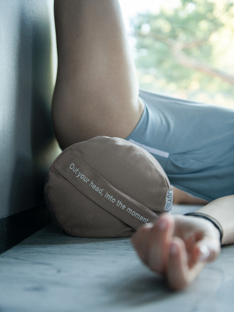 beżowy bolster wałek do jogi z gryką Into The Moment - podczas ćwiczeń