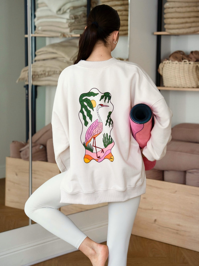 Kremowa luźna bluza bawełniana z grafiką czapli na plecach - JOYINME x Ewa Konstantynowicz Goss, outfit sportowy z legginsami w kremowym odcieniu i z kolorową kauczukową matą do ćwiczeń