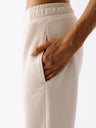 Kremowe bawełniane spodnie dresowe damskie Evolve - widok na kieszenie i haft z logo