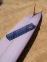 Niebieska antypoślizgowa mata do ćwiczeń jogi 3 mm z grafiką surferki - zrolowana mata na plaży