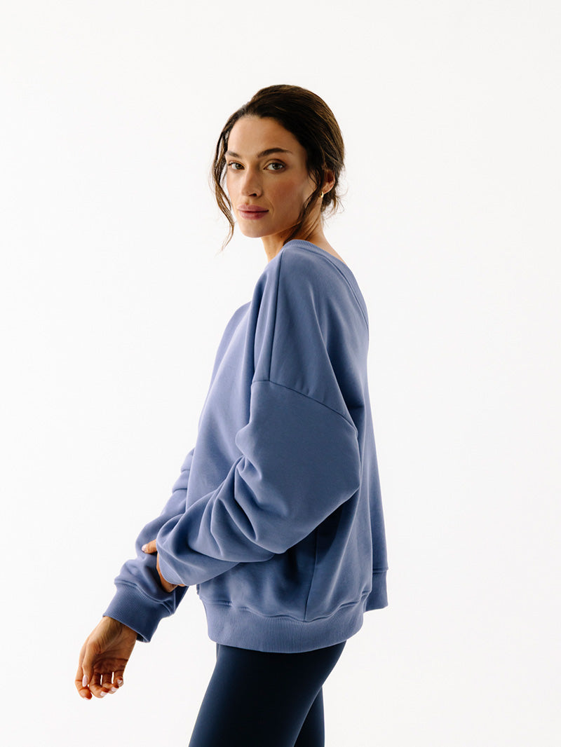 Niebieska oversize bluza z dekoltem na plecach V-Essence - widok na szerokie rękawy