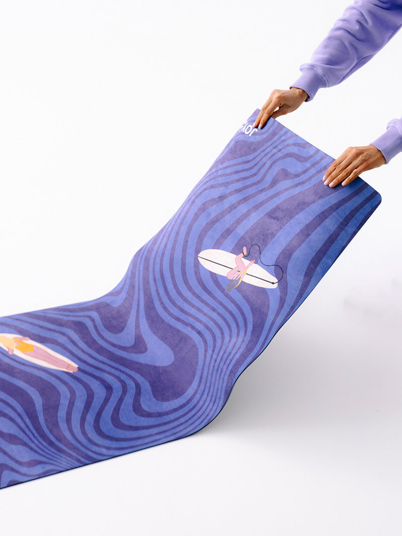 Niebieska kauczukowa mata do ćwiczeń jogi 3 mm z grafiką surferki - zbliżenie na warstwę na powierzchni podczas rozkładania