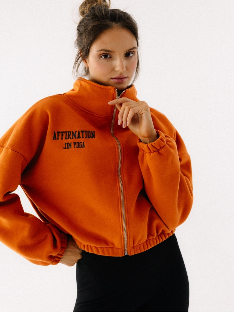 Rozpinana bluza ze stójką w pomarańczowym
grafitowym haftem Affirmation z wysokiej jakości bawełny