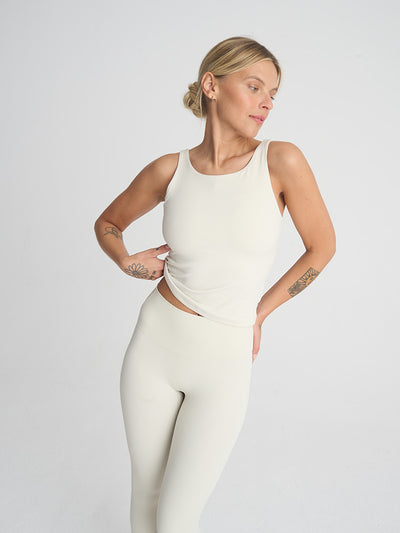 Biała koszulka do jogi na ramiączkach Release - modelka w zestawie z białymi legginsami